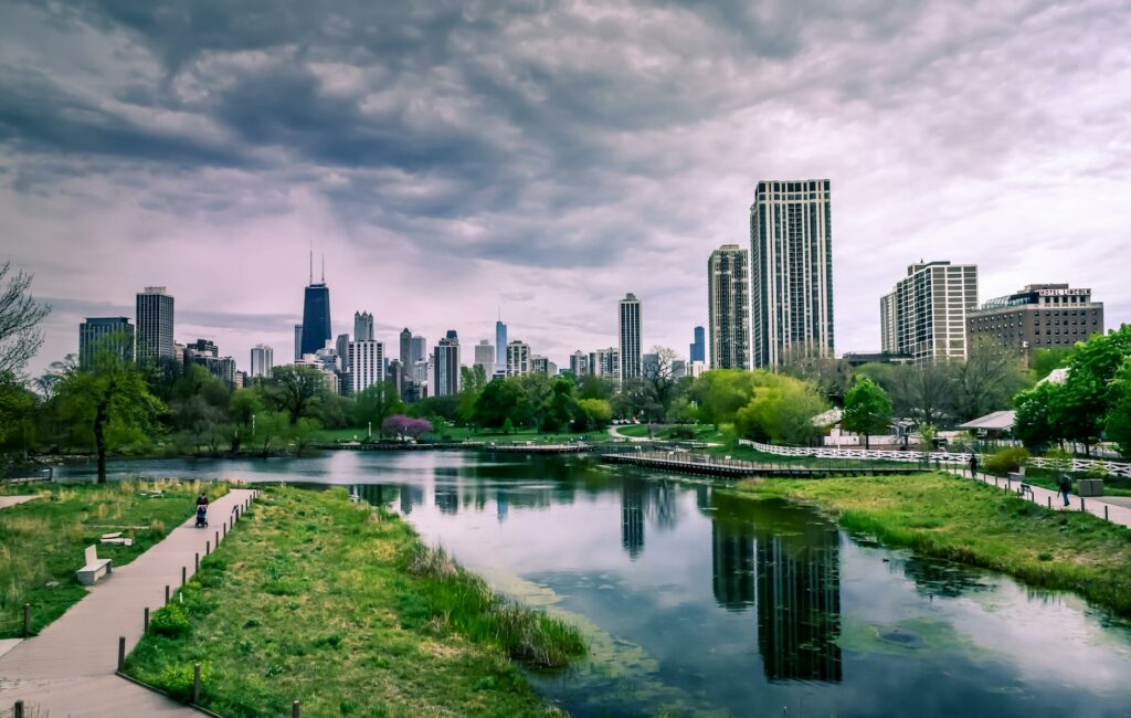 pexels photo 1209978 1209978 Dramatic view of Chicago skyline with reflections over Lincoln Park Lagoon on a cloudy day.